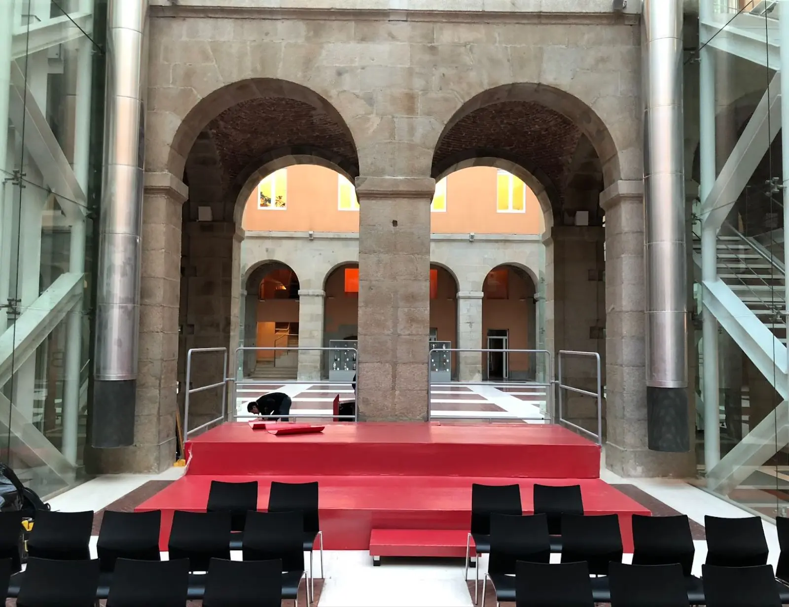 Patio interior con escenario y sillas negras