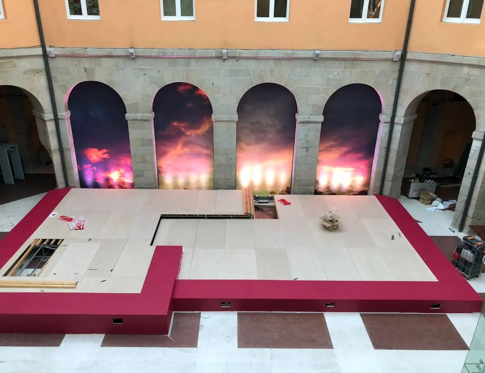 Escenario en construcción con arcos y luces coloridas.