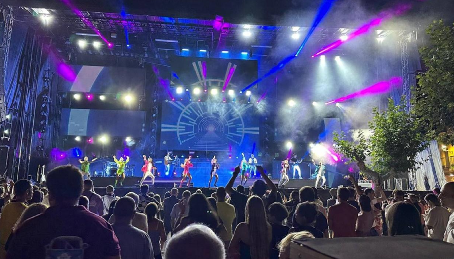 Concierto en vivo con luces y multitud entusiasta.