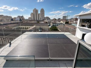 Tarima con faldón negro y sillas sobre el escenario en un espacio cubierto de un colegio.